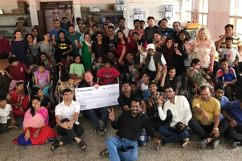 A group of people at the Snehalaya Charity home happily receiving a cheque from My Home Move charitable trust