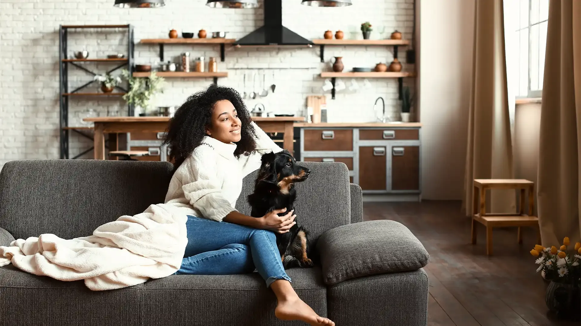 young woman in her flat smiling as she prepares to move into her first home