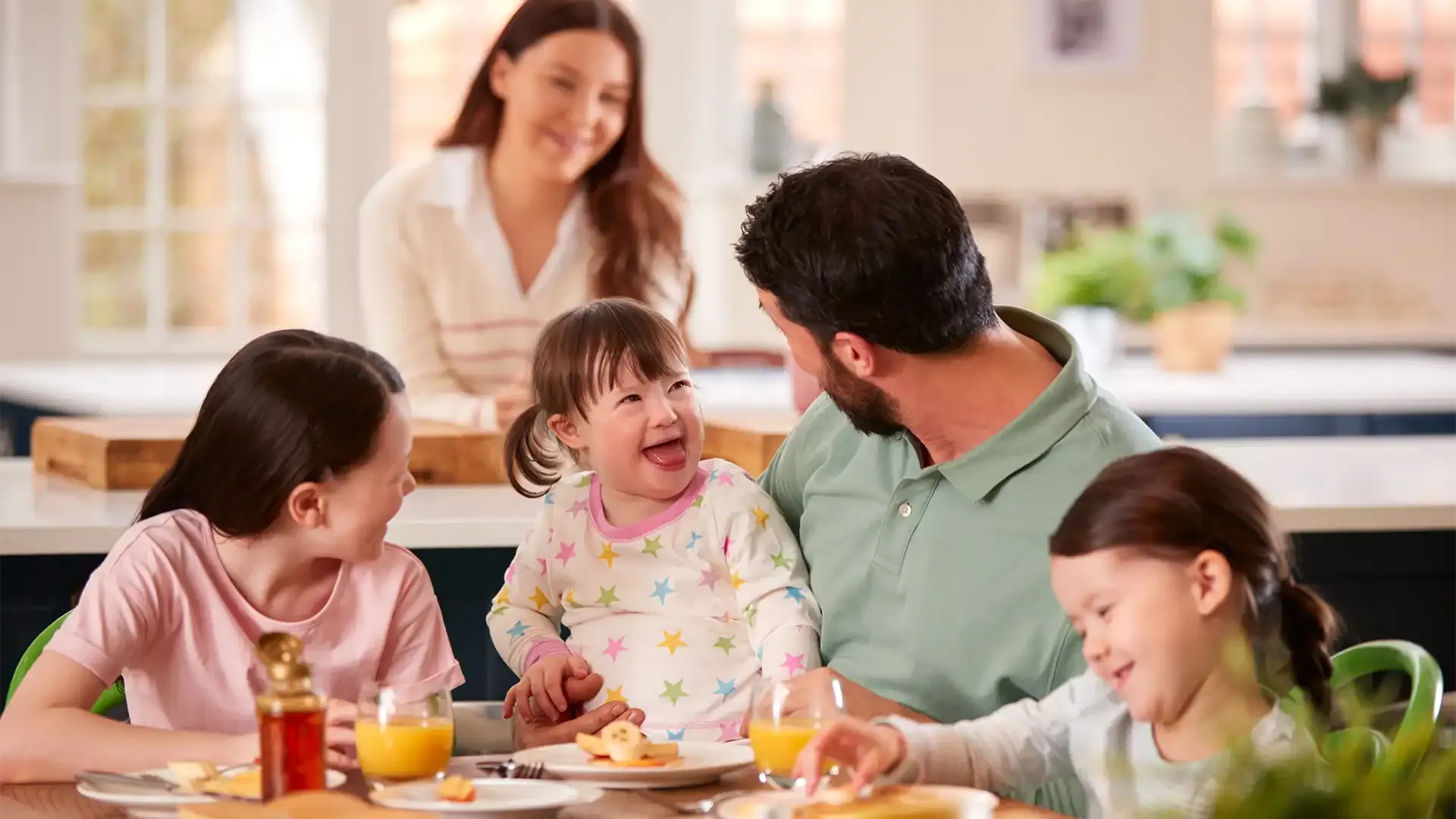 family enjoying dinner together happy as they decided to sell their house to move to a bigger one