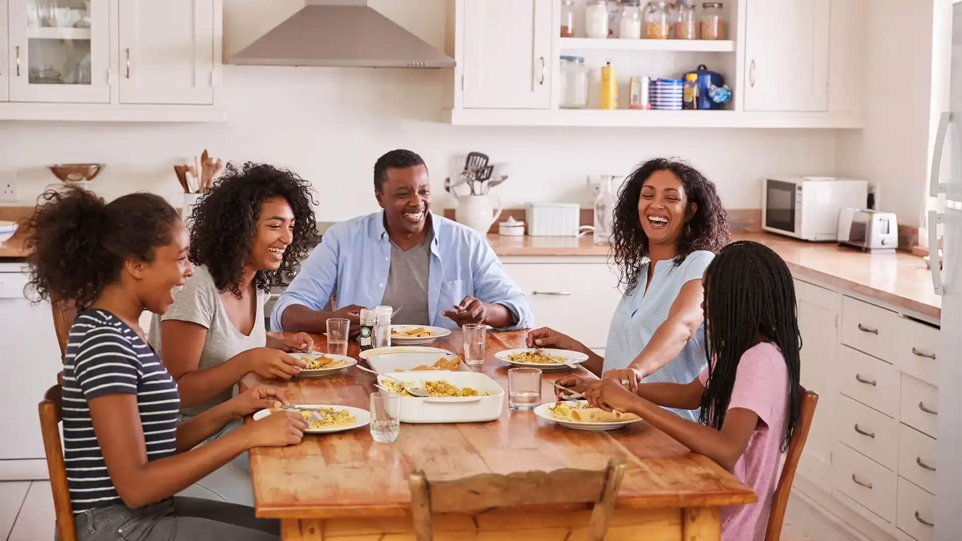 a happy family enjoying dinner celebrating finding a new home to buy