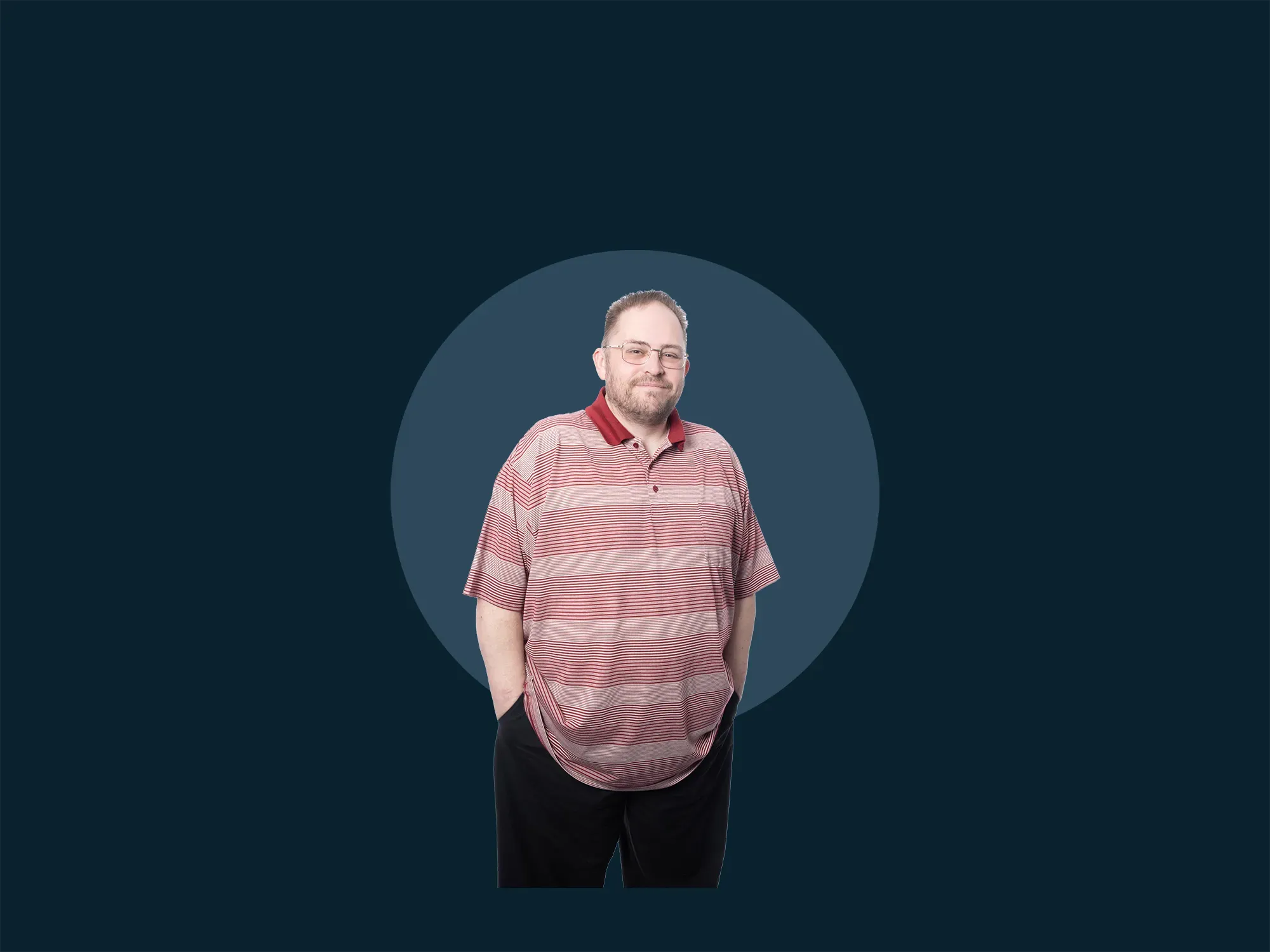 Man in a striped polo shirt and glasses stands smiling with hands in pockets against a dark blue background with a circular design.