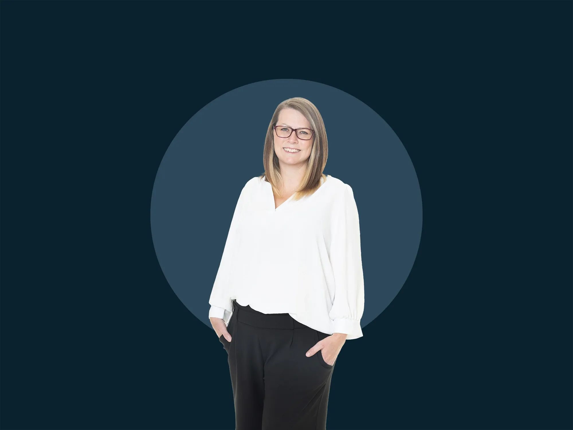 Lynsey Seymour wearing glasses, a white blouse, and black pants stands against a dark blue background with a lighter blue circle.