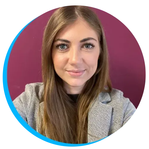 Headshot of Abigail Bates with long brown hair wearing a grey blazer smiling against a maroon background.