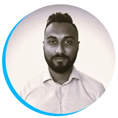 Headshot of Kavi Chaun with a beard and short hair, wearing a light-colored shirt, in a circular frame with a blue border.