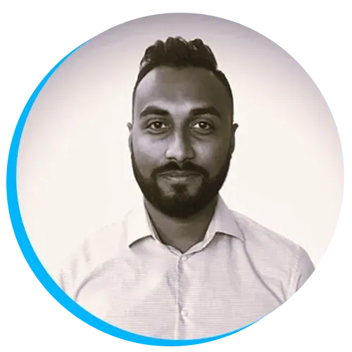 Headshot of Kavi Chaun with a beard and short hair, wearing a light-colored shirt, in a circular frame with a blue border.