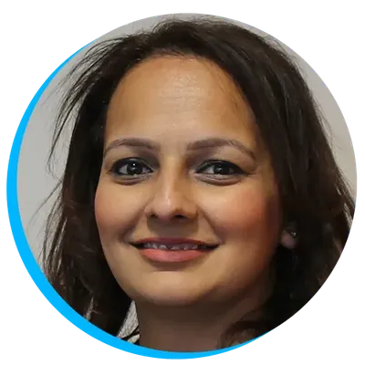 Parminder Phull smiling with dark hair, wearing subtle makeup, against a neutral background with a blue circular border.