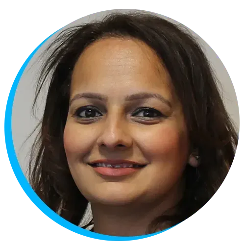 Parminder Phull smiling with dark hair, wearing subtle makeup, against a neutral background with a blue circular border.