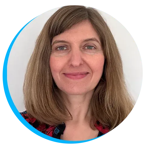 Headshot of Cathy with shoulder-length brown hair smiling, wearing a patterned top. Blue circular frame surrounds the image. White background.