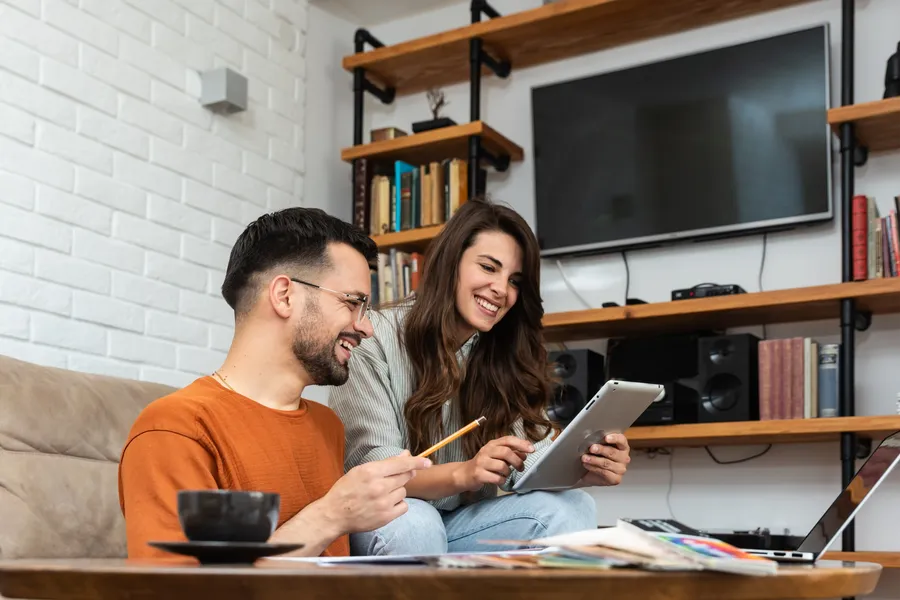 beautiful young couple looking at their conveyancing quote happy with the fees as it means they can afford to buy their first home