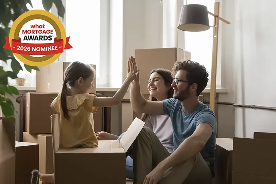 Family high-fiving in a room filled with cardboard boxes, indicating a recent move. A "What Mortgage Awards 2026 Nominee" badge is visible in the top left hand corner