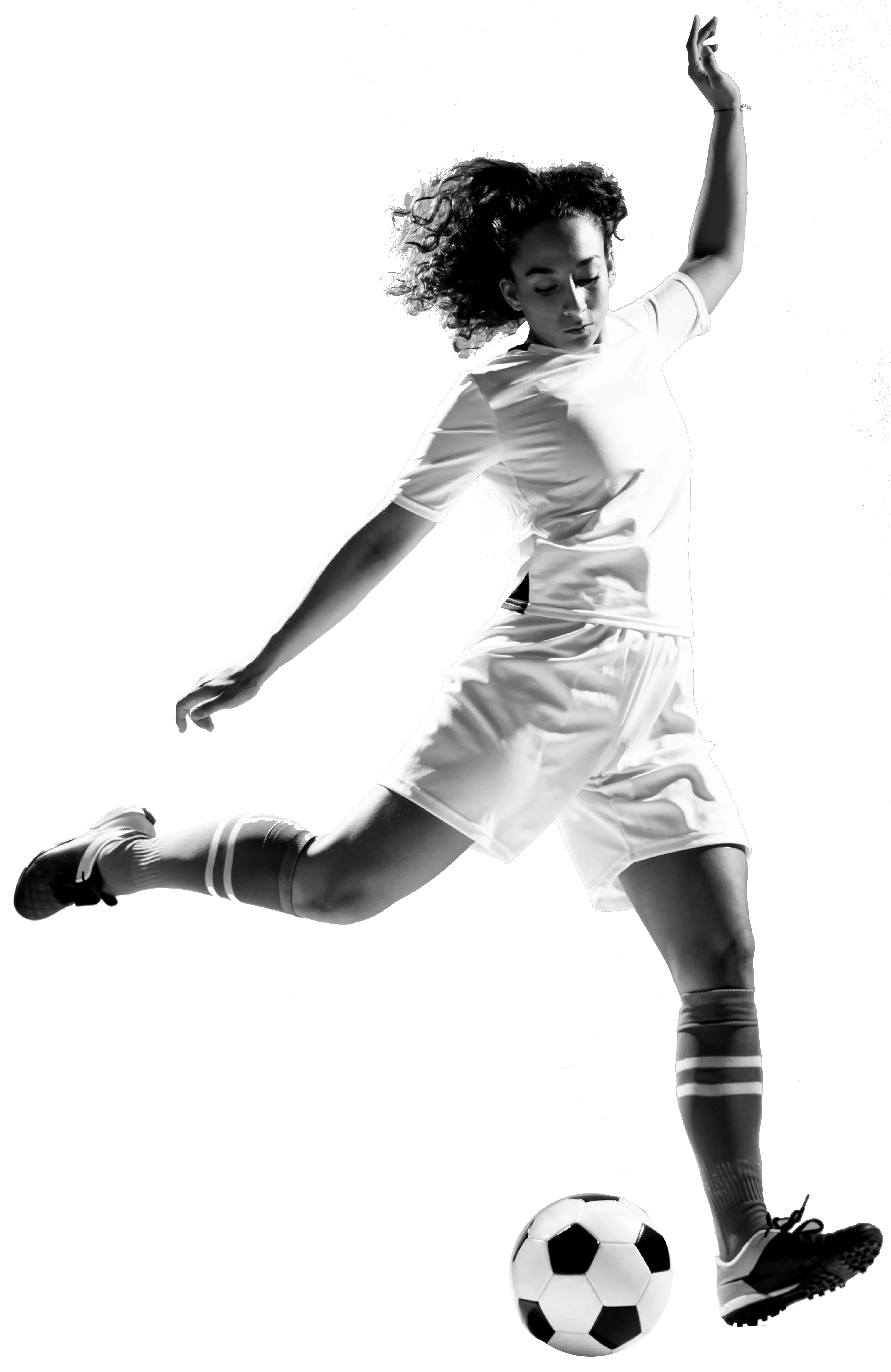 Female soccer player in motion, wearing a uniform, poised to kick a soccer ball, displaying athleticism and focus. Black and white image.