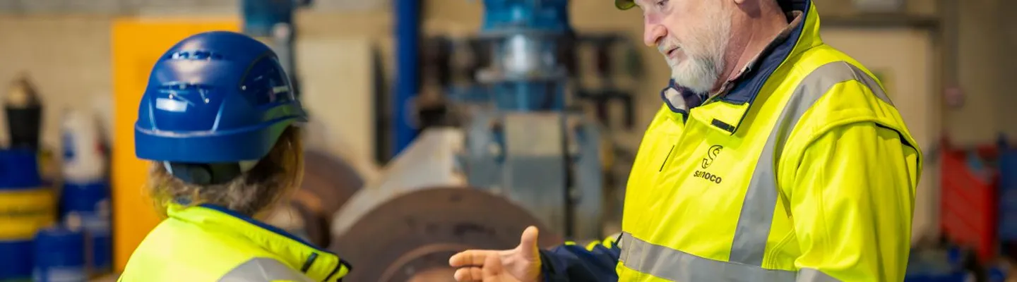 Sarens employee explaining work and technical operations to a colleague on site