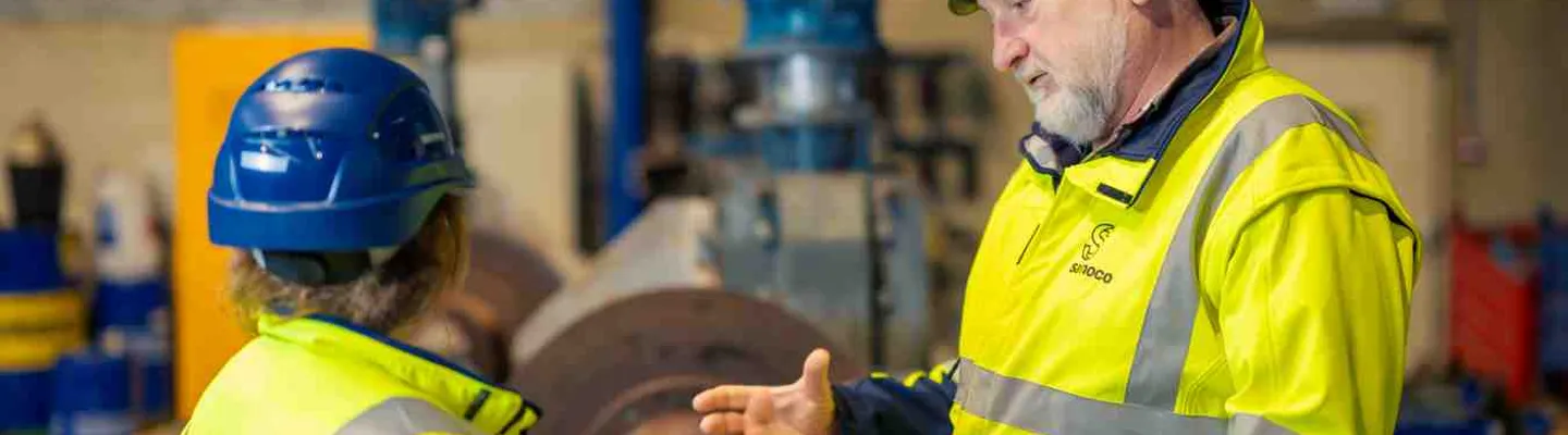 Sarens employee explaining work and technical operations to a colleague on site