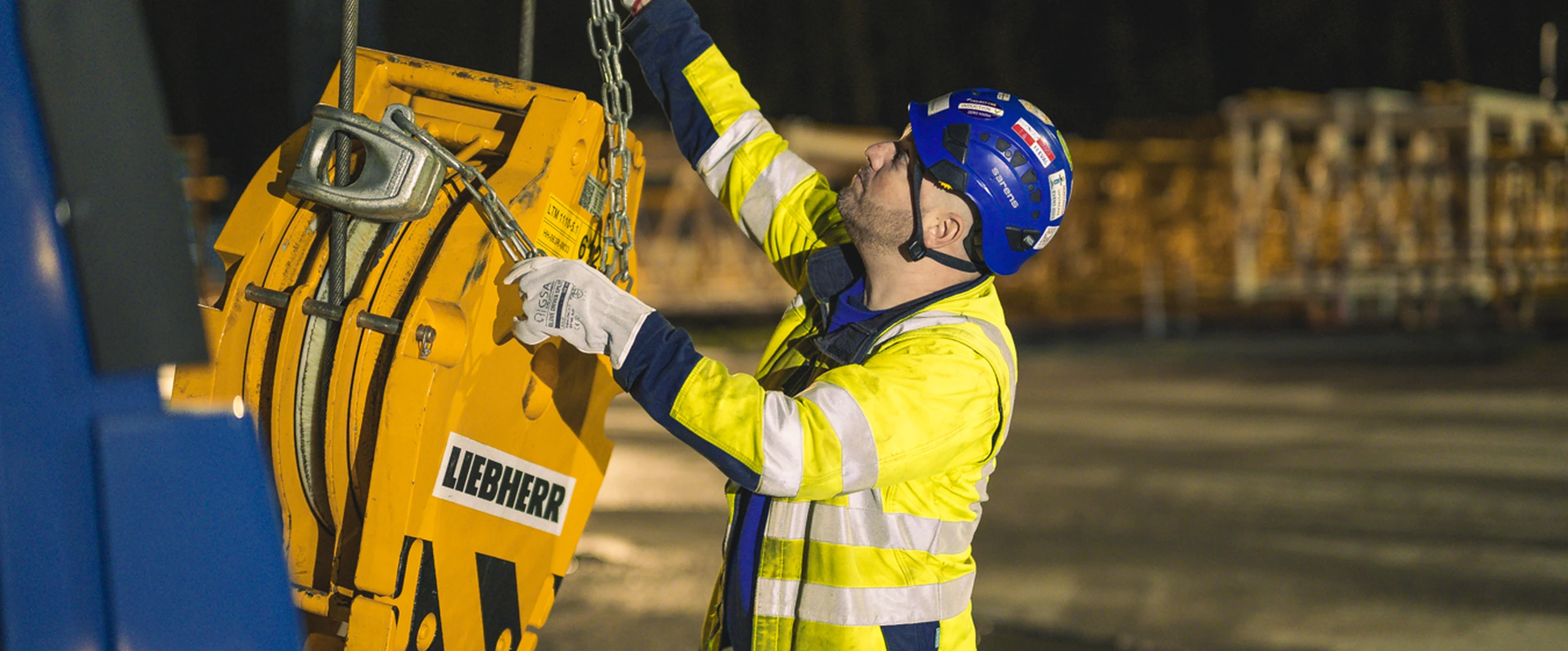 Sarens crane operator standing beside heavy lifting equipment on site
