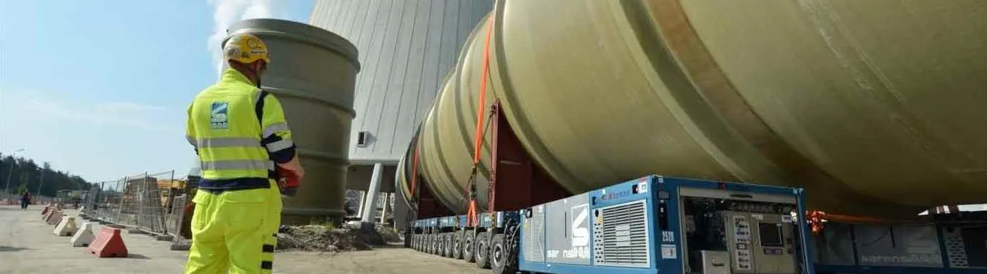 Sarens operations employee in high-visibility workwear inspecting heavy lifting equipment on site