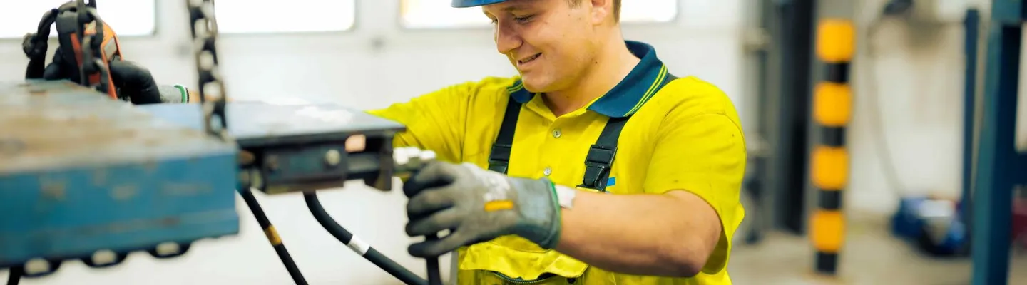 Sarens employee working on crane components in a workshop as part of heavy lifting operations