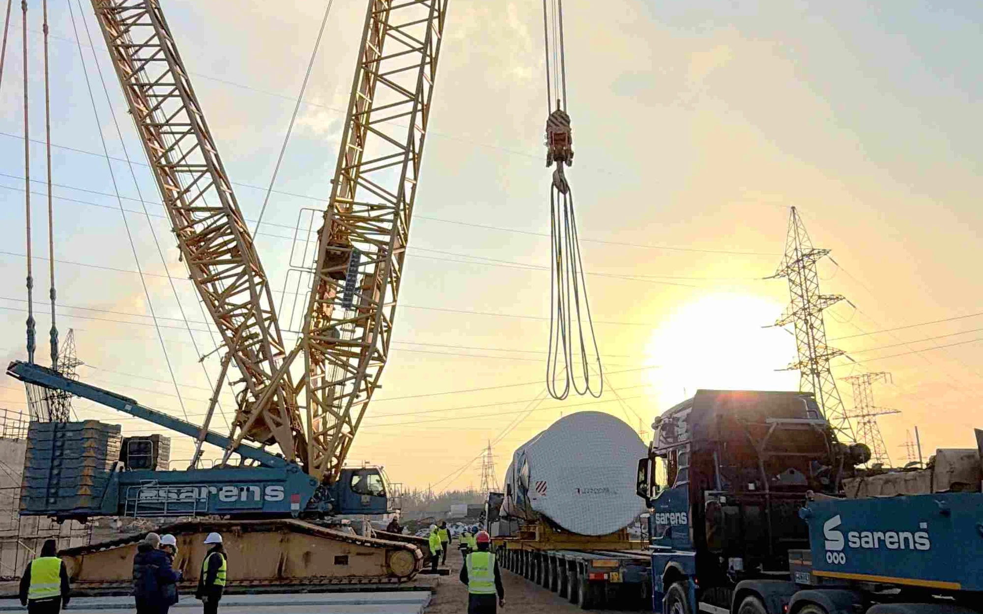 Sarens employees working together around a heavy lifting crane on site