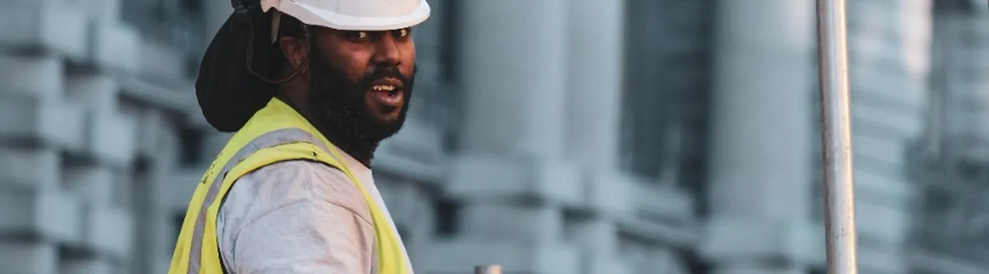 Sarens employee wearing a safety helmet working with heavy lifting equipment and metal plates