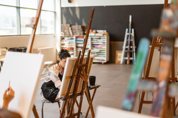 Une femme peint sur une toile.