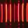 Leuchtend rote, vertikale Lichtbalken vor einem dunklen Hintergrund erzeugen ein futuristisches, symmetrisches Muster mit Spiegelungen.