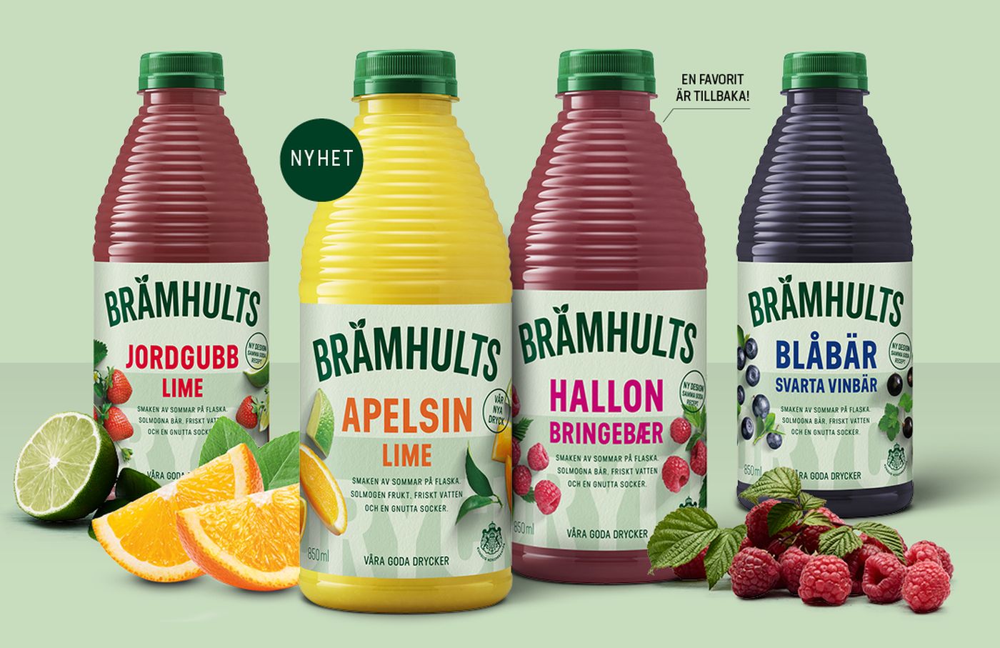 Four Brämhults juice bottles with flavors: strawberry lime, orange lime, raspberry, and blueberry blackcurrant, displayed with fresh fruits.