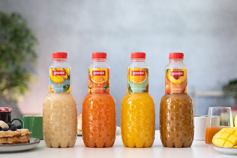Four granini Trinkgenuss on a breakfast table in front of grey background with a tree in the left corner