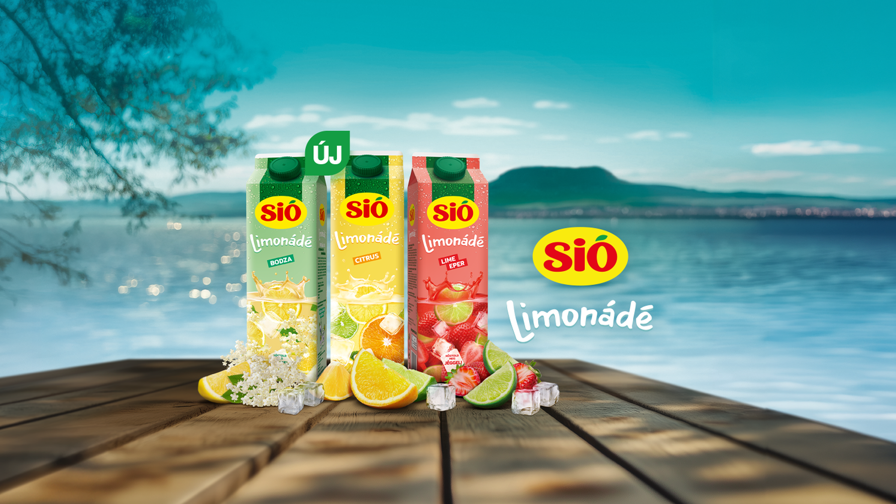 Three SiÓ lemonade cartons in elderflower, citrus, and lime-strawberry flavors on a wooden table by a lake, surrounded by fruit and ice.