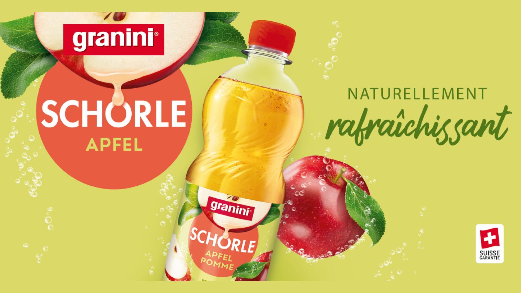 Bouteille de Granini Schorle Pomme devant des feuilles vertes et des bulles – boisson suisse naturellement rafraîchissante.