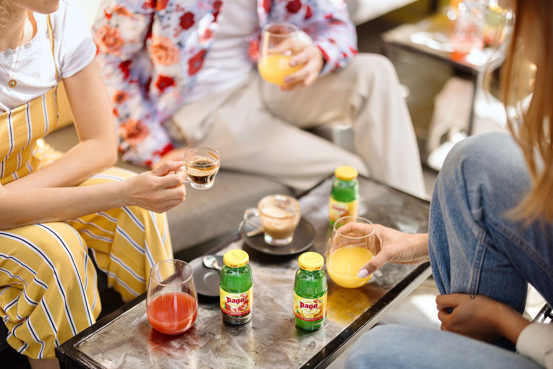 3 Leute sitzen am Tisch mit 0,2l Flaschen Pago und Kaffee.