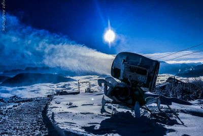 Schneekanone im Schnee, Nebelmeer im Tal bei Nacht und Vollmond