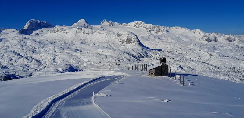 Frisch präparierte Spur führt zur Heilbronner-Kapelle im tief verschneiten Hochplateau am Dachstein.