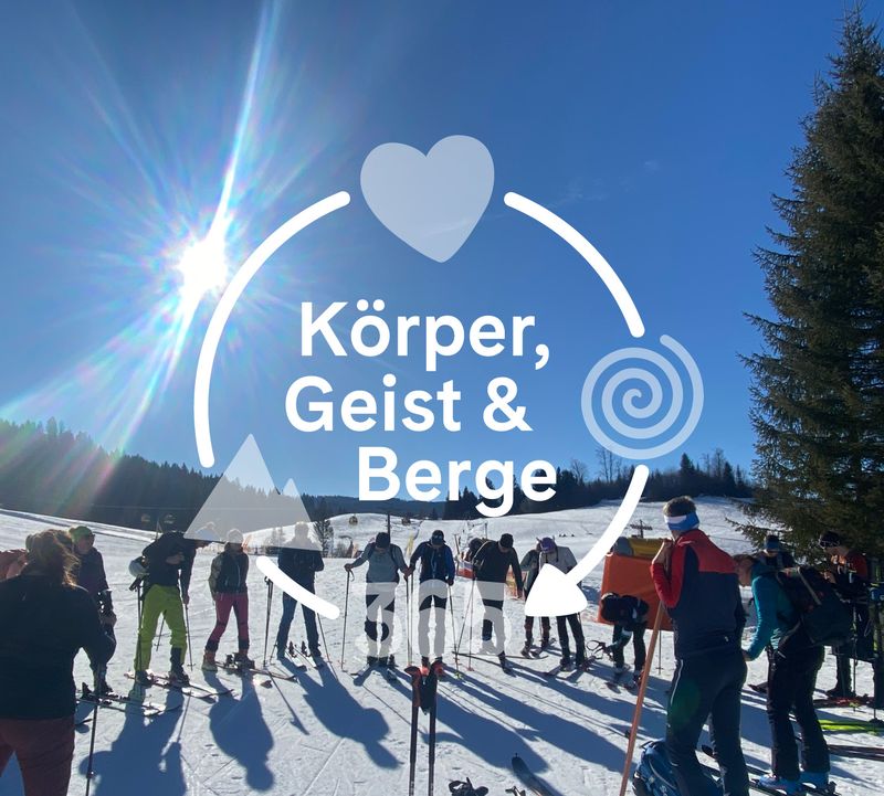 A group of people stand at the edge of a sunny, snow-covered ski slope surrounded by trees. The text ‘Body, Mind & Mountains’ is overlaid with a heart and spiral symbol.