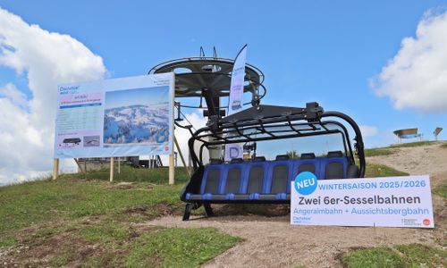 Ein neuer blauer Sechser-Sessellift steht im Freien und kündigt seine Eröffnung für die Wintersaison 2025/2026 an.