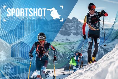 Three ski tourers in racing gear are touring up a snowy mountain slope in front of a mountainous background and the ‘Sportshot Photography’ logo in the corner.