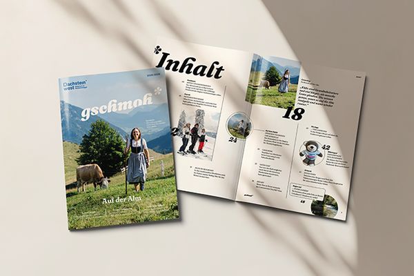 Ein Magazincover mit einer Frau in traditioneller Kleidung und einer Kuh in einer Berglandschaft neben einem offenen Magazin, das seinen Inhalt zeigt.