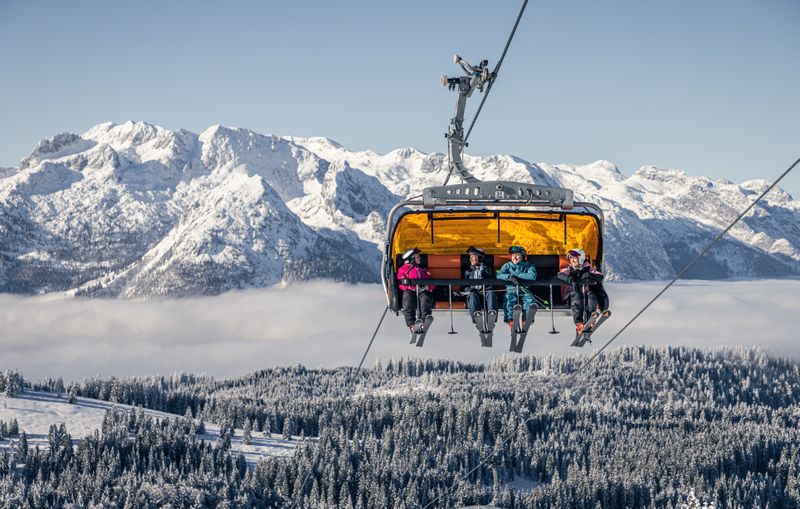 Vier Personen im Sessellift in Dachstein West
