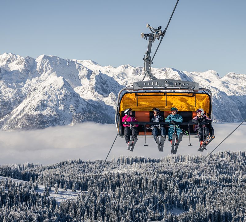 Vier Personen im Sessellift in Dachstein West