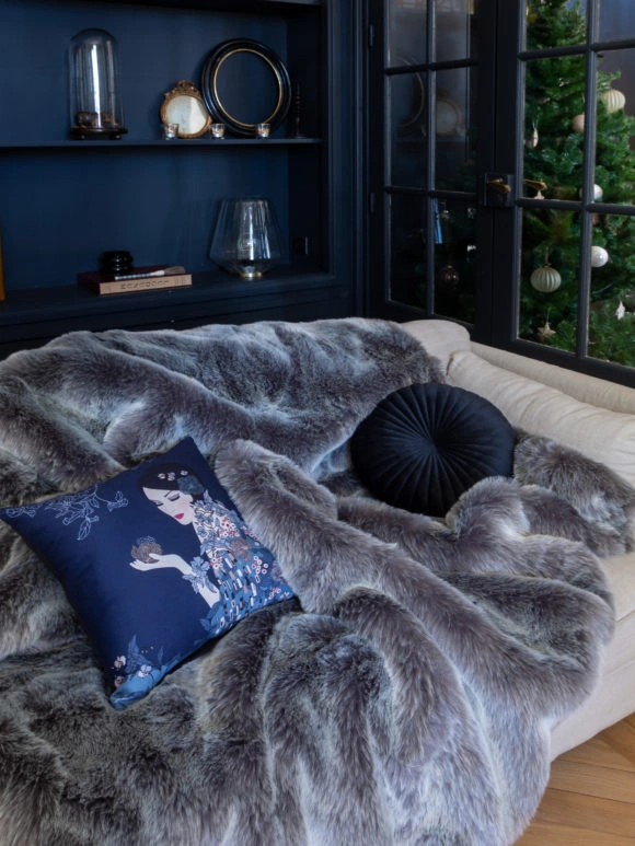 Un plaid en fausse fourrure sur un canapé à Noël