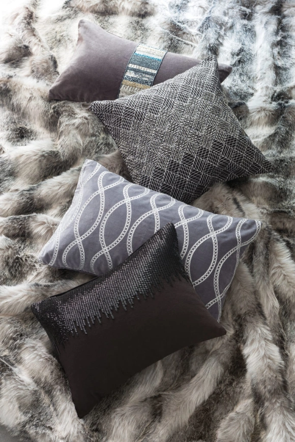 Des coussins sur un plaid en fausse fourrure