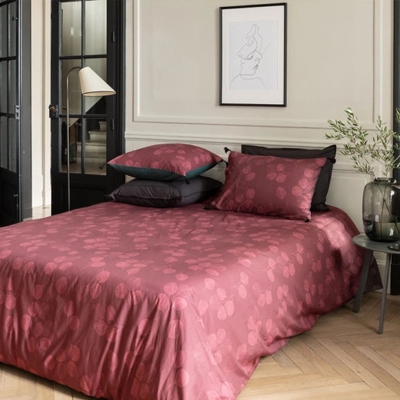 Une chambre avec une housse de couette rouge