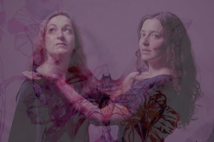 Two figures with long wavy hair stand closely together against a purple-toned background, overlaid with translucent floral patterns.