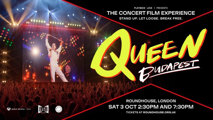 Large crowd watches concert film screening with bright stage lights, giant screen, and event promotion.