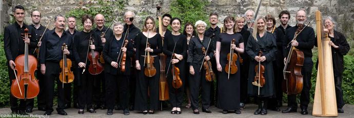 Group of people wearing black, holding instruments outdoors