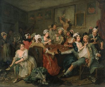 An 18th‑century painting depicting a crowded interior scene where several people gather around a table, with objects scattered on the floor and detailed artwork on the walls.