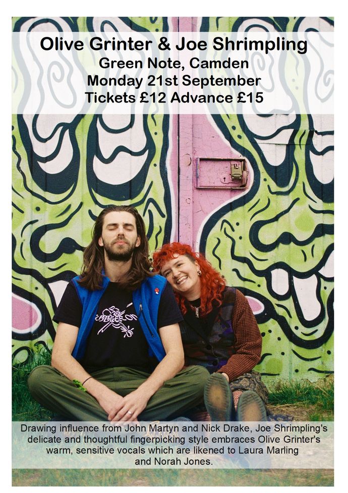 Two people sit on ground against brightly coloured cartoon spraypainted wall