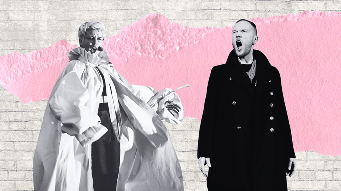 Two individuals in dramatic poses: one in a voluminous outfit with a microphone, the other in a long coat, against a pink and brick background.