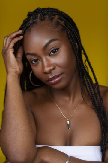 Olivia Francis looking into camera in front of a yellow background