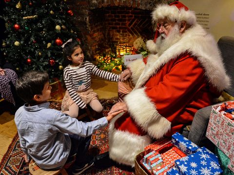 Santa's with kids by fireplace in Christmas Grotto at Lauderdale House