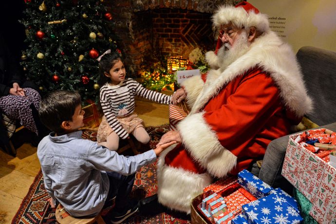 Santa's with kids by fireplace in Christmas Grotto at Lauderdale House