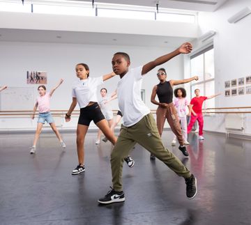 Group of kids dancing with their left hand in the air